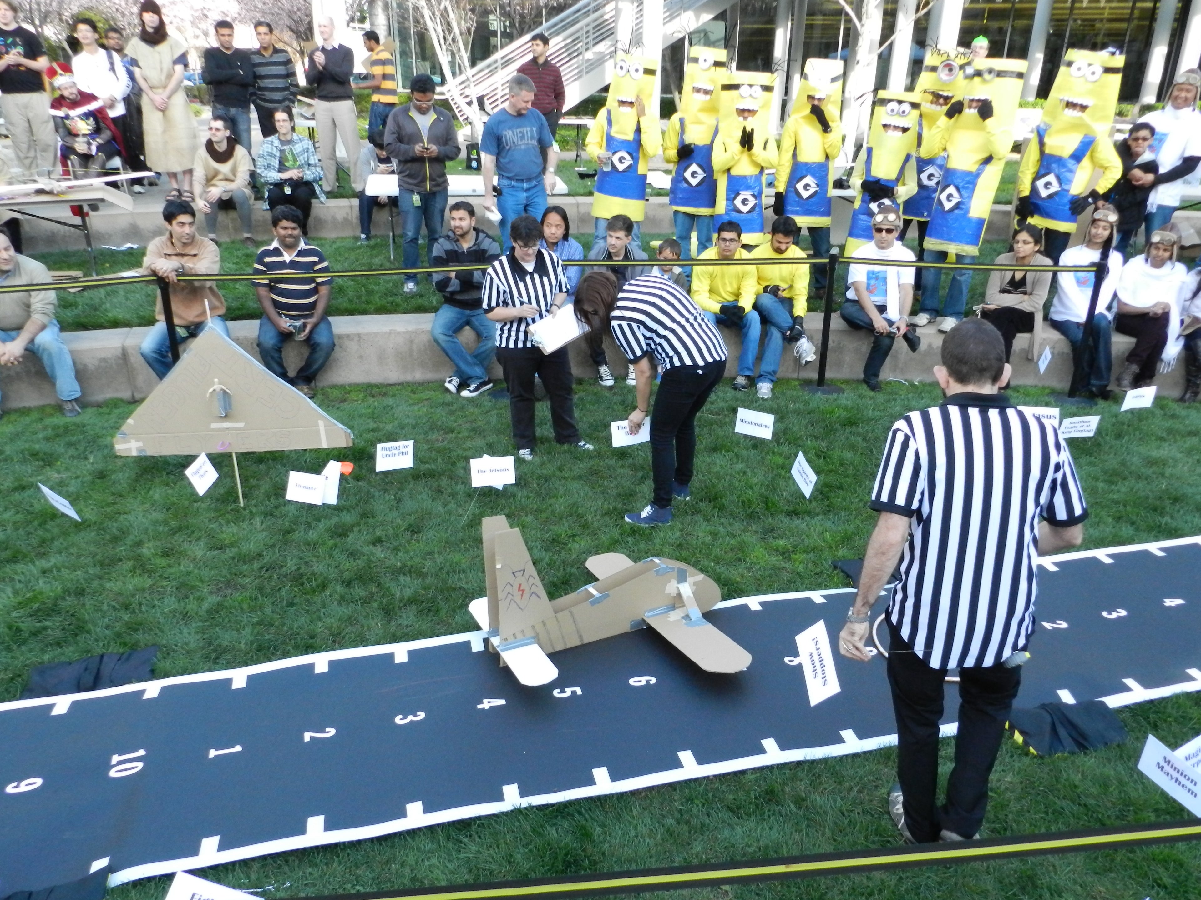 three referees and minions with large paper airplanes