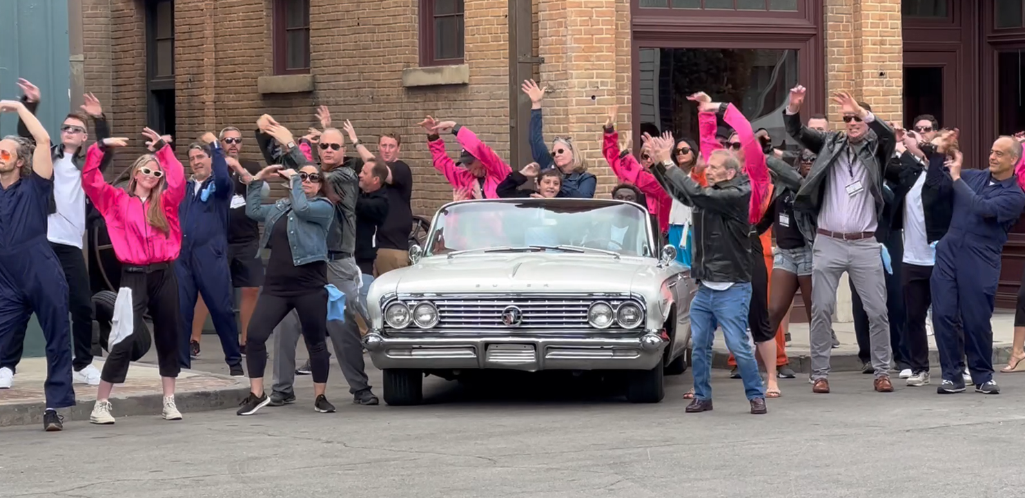 a group of people with their hands up and a car