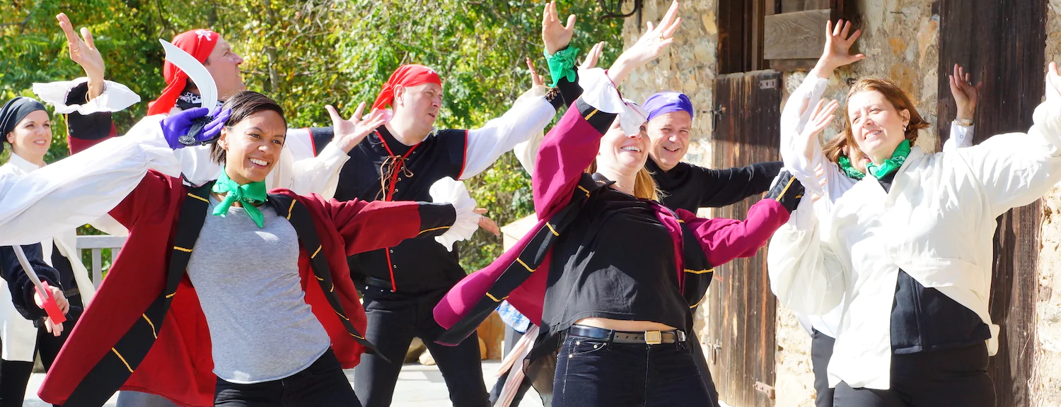 a group of people dancing with pirate outfits