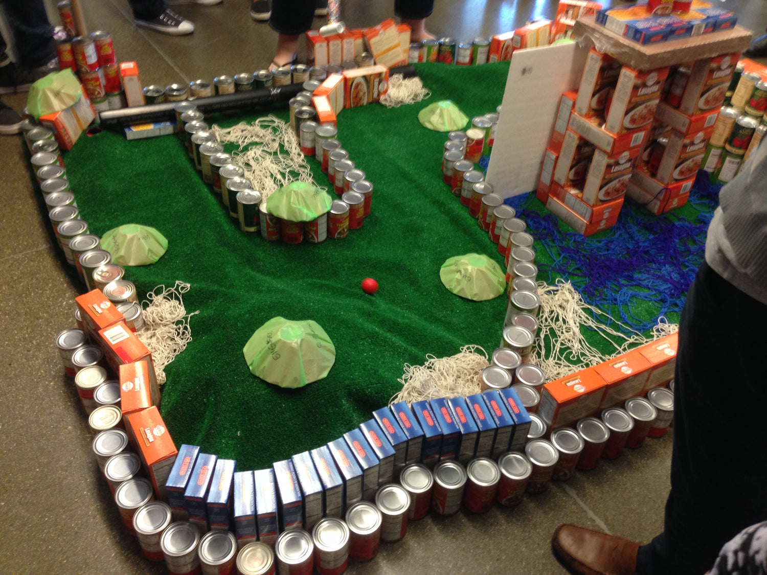 a golf course made of cans and lasagna boxes