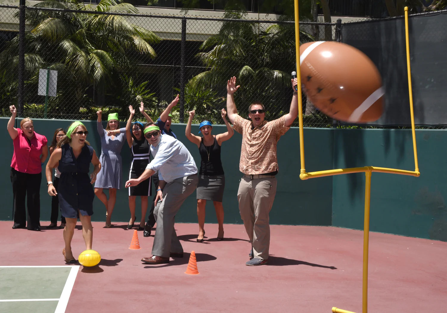 a group of people with their hands in the air and a football in a field goal