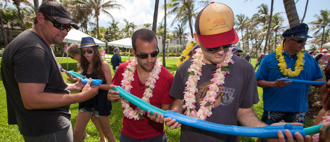 people with leis holding cut pool noodles and marbles