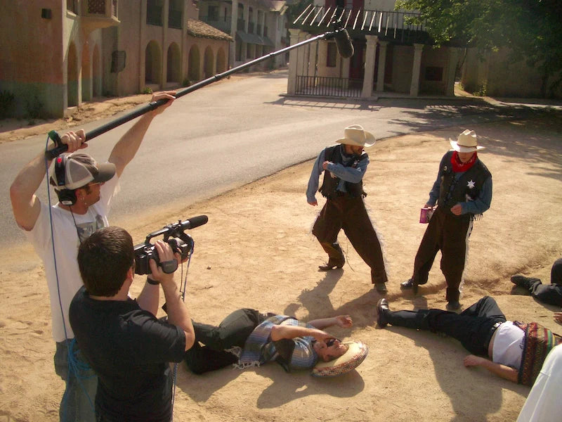 people filming cowboys with a boom mic